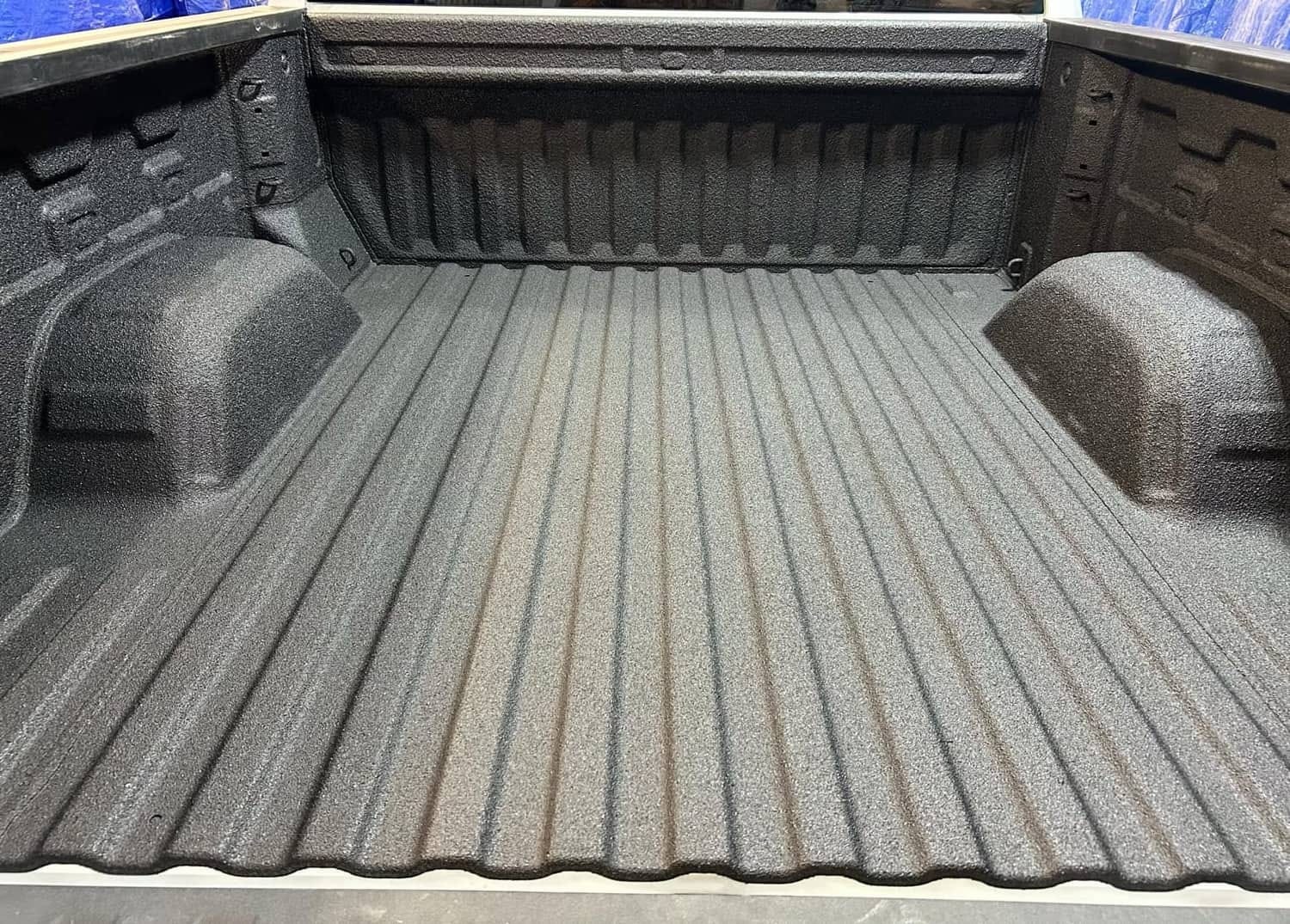 Close view of the textured black bed liner finish across a truck bed floor