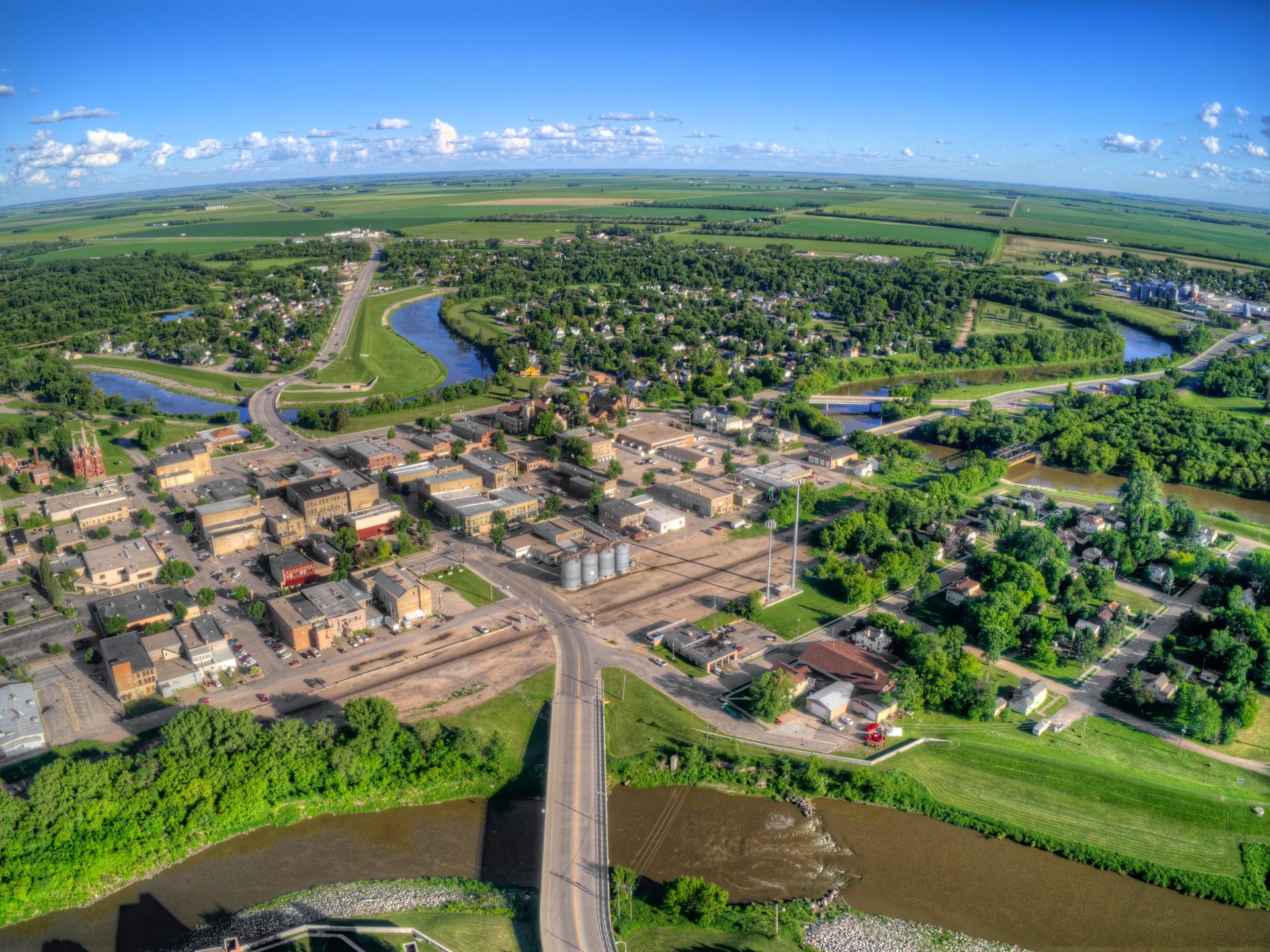 Aerial view of a small Minnesota town surrounded by farmland and grain elevators